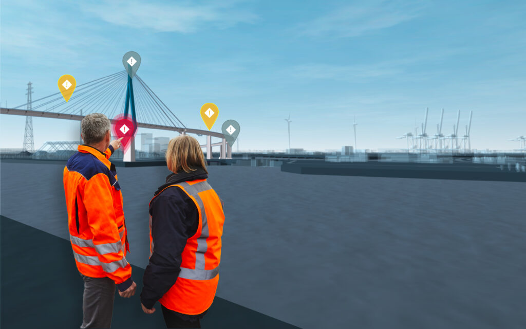Zwei Personen in orangen Warnwesten blicken auf eine Hafenanlage mit Brücke, Windrädern und mehreren farbigen Standortmarkierungen.
