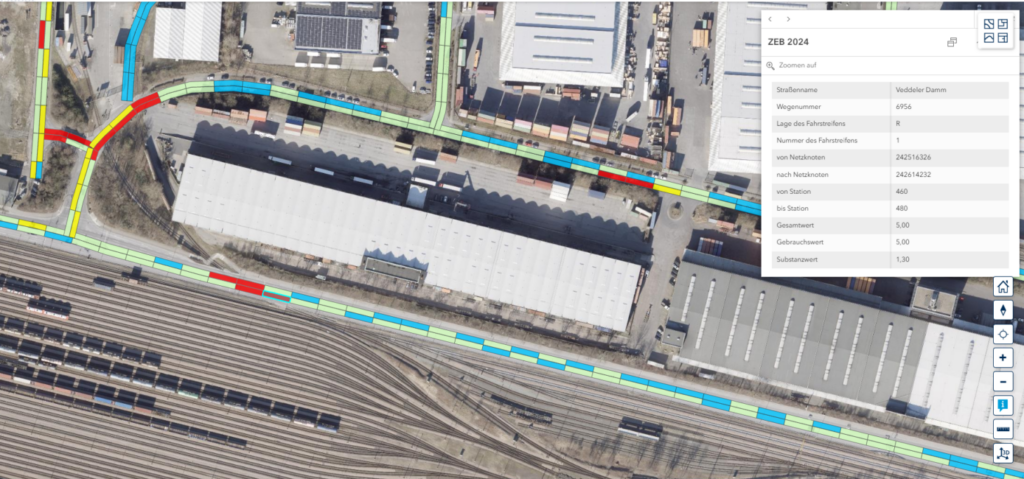 Luftaufnahme eines Bahnhofs mit Gleisen, einem langen Gebäude und farblich markierten Wegen sowie einem eingeblendeten Informationsfenster mit technischen Daten.